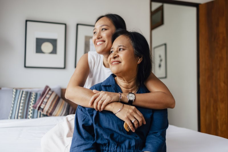 A smiling female embracing her mother after zone control system was installed in their home.